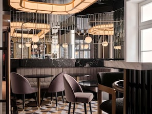 A bar area with seating, pendant lighting, and a marble countertop. - The Crown Krakow Center - Handwritten Collection ACCOR (Kraków)