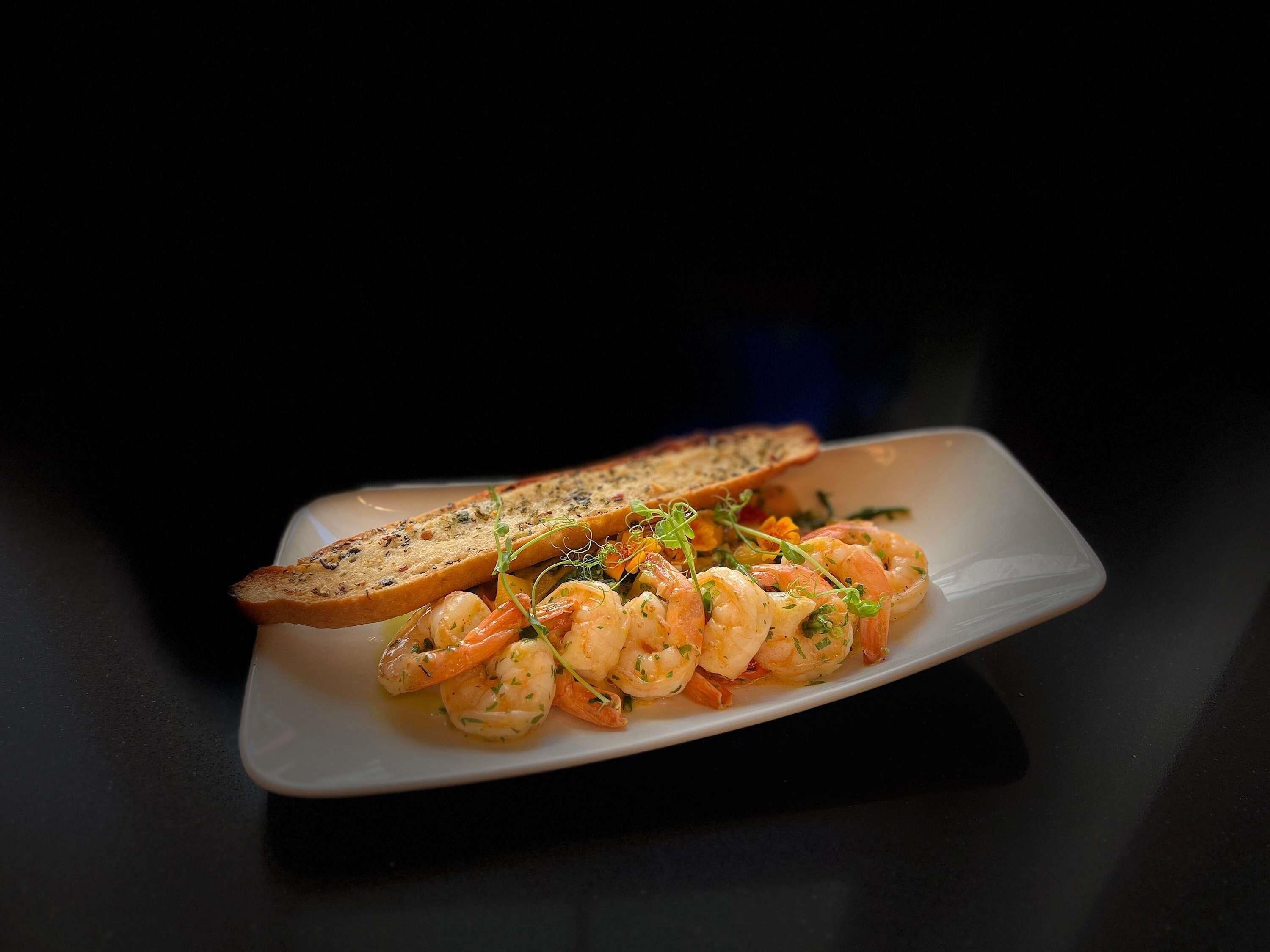 A plate with shrimp and toasted bread.