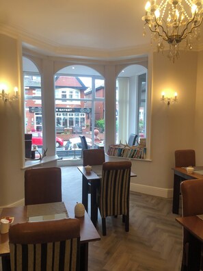 A dining area with a bay window, wooden flooring, and a chandelier. - Number42  (Blackpool)