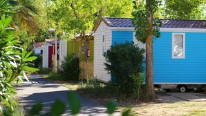 Una hilera de casas móviles con entrada pavimentada y vegetación circundante.