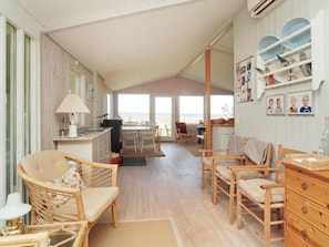 Een ruime kamer met een eethoek, keuken en uitzicht op zee.