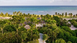 A tropical resort with a view of the ocean, surrounded by palm trees and a golf course.