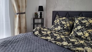 Ein Schlafzimmer mit einem Bett, einem Nachttisch, einer Lampe und einer Wand mit strukturierter Oberfläche.