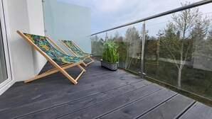 A balcony with two lounge chairs and a potted plant. - A comfortable apartment close to the seaside beach (Gaski)