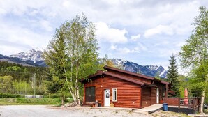 Une cabane en bois avec une porte d’entrée, des fenêtres et un petit porche.
