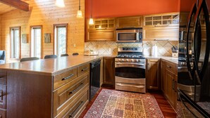Une cuisine moderne avec des meubles en bois, des appareils en acier inoxydable et un grand îlot central.