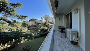 Un balcon avec un sol en pierre, une table et des chaises.