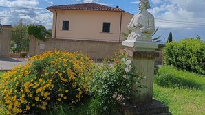 Une statue dans un jardin, avec un bâtiment en arrière-plan.
