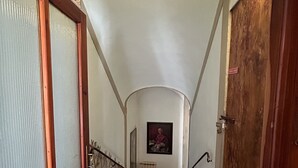 Un escalier avec une rampe en bois, une porte en verre à gauche et une porte à droite.