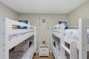 Habitación infantil con literas y decoración temática náutica.
