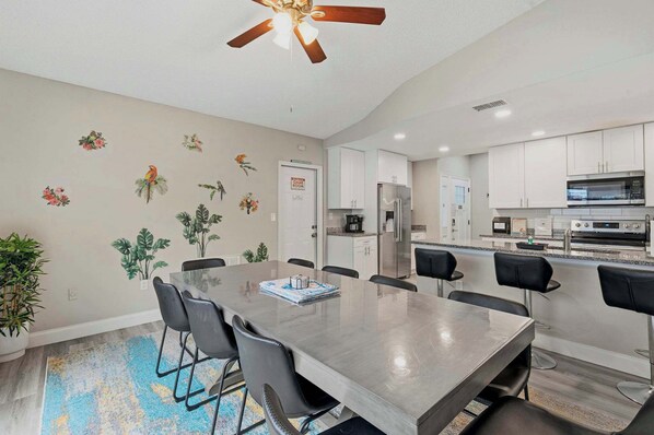 A modern kitchen with white cabinets, a stainless steel refrigerator, and a built-in oven.