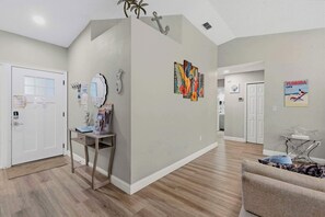 A hallway with a reception desk, a door with a 'Please Keep Closed' sign, a wall-mounted mirror, and a Florida Life magazine poster.