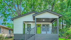 A two-story house with a covered porch and a small staircase. - Elegant Atlanta Haven | 3 Bedroom Near Downtown (Atlanta)