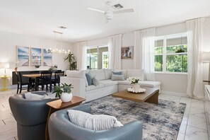 A modern living room with a sofa, coffee table, and dining area.