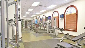 A gym with treadmills, elliptical machines, and weightlifting equipment.