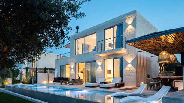 A modern two-story house with a swimming pool, outdoor seating, and a dining area.