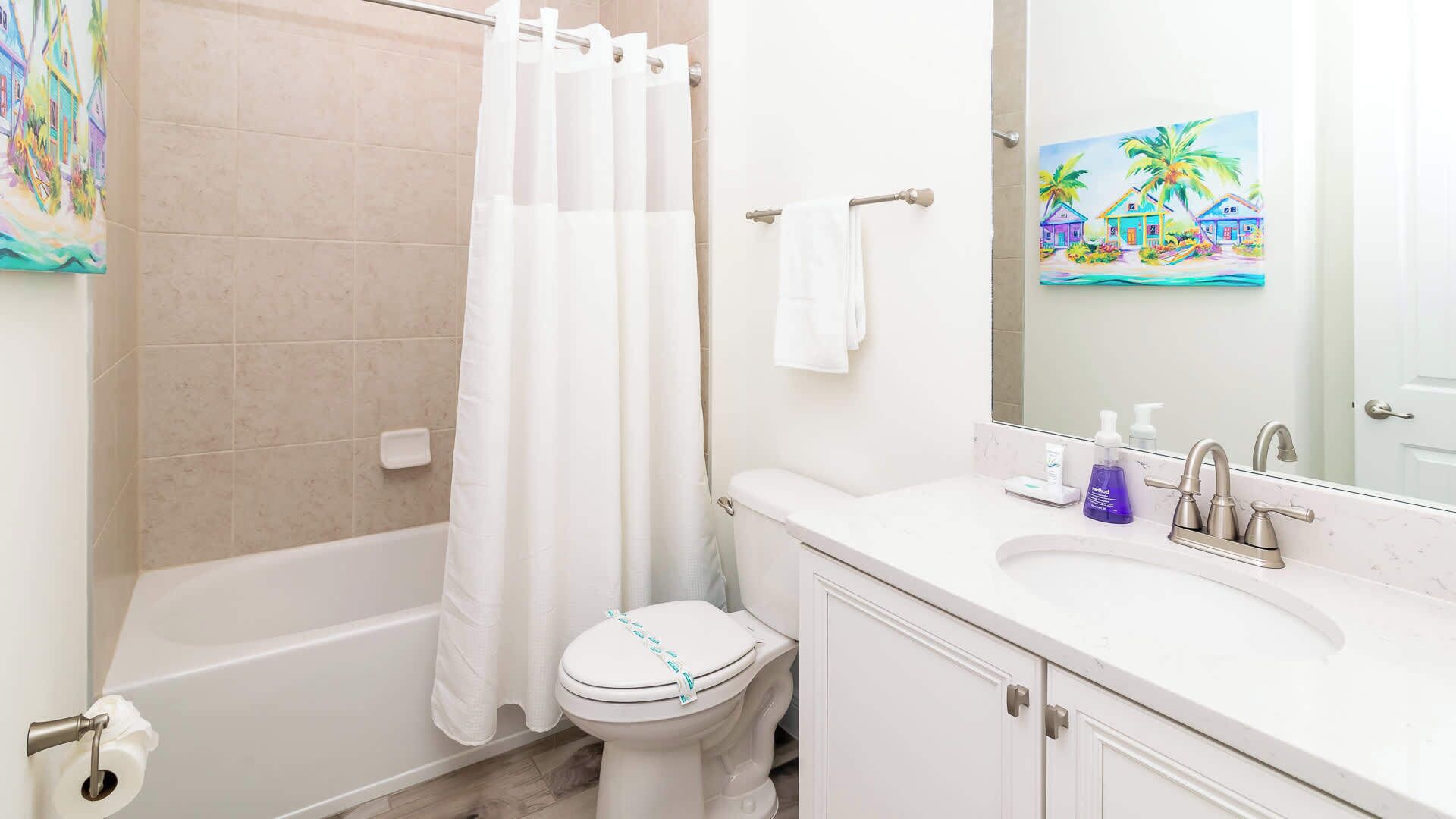 A bathroom with a bathtub, toilet, and sink.