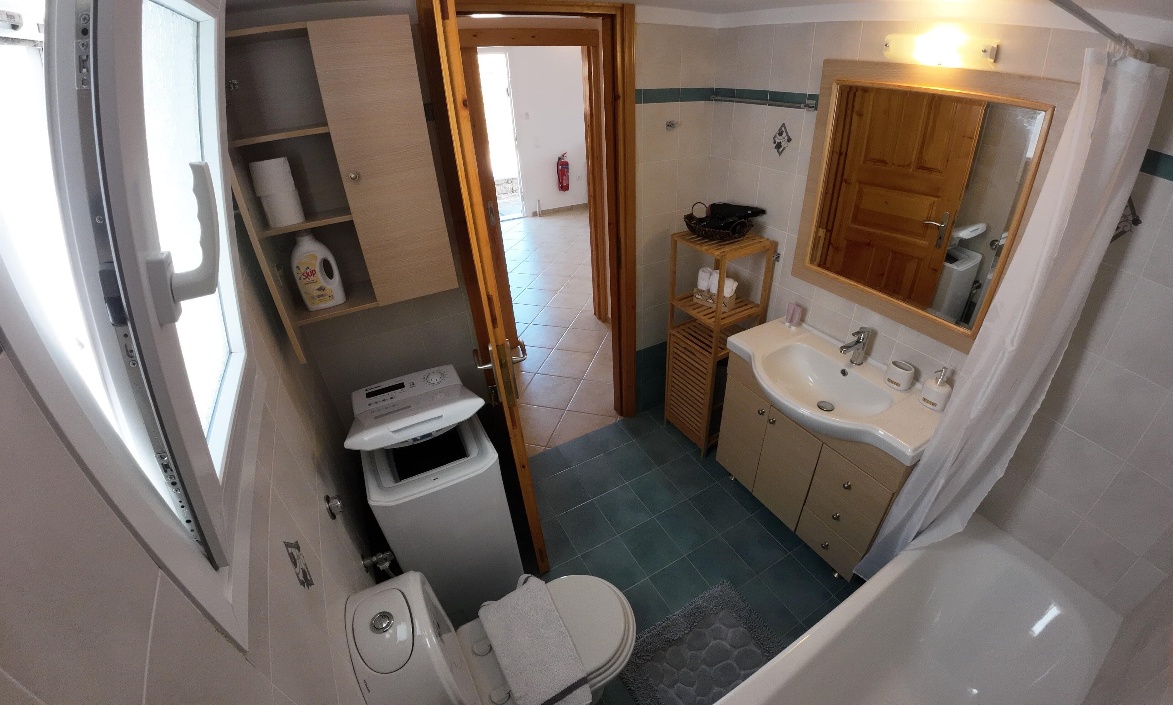 Un baño pequeño con inodoro, lavamanos y ducha.
