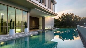 A modern hotel with a swimming pool, large windows, and a balcony. - Welladee Wellness Chiang Mai (Chiang Mai)