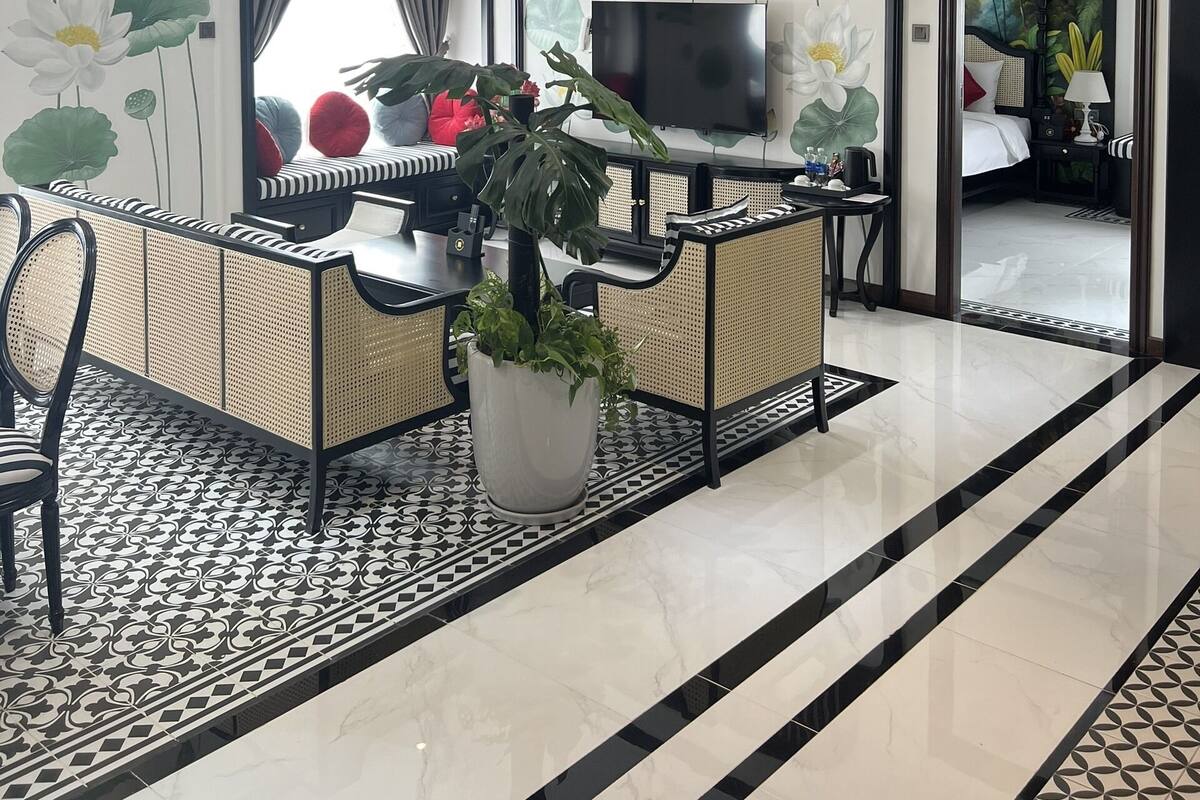 A modern living room with a flat-screen TV, a ceiling fan, and a large potted plant.