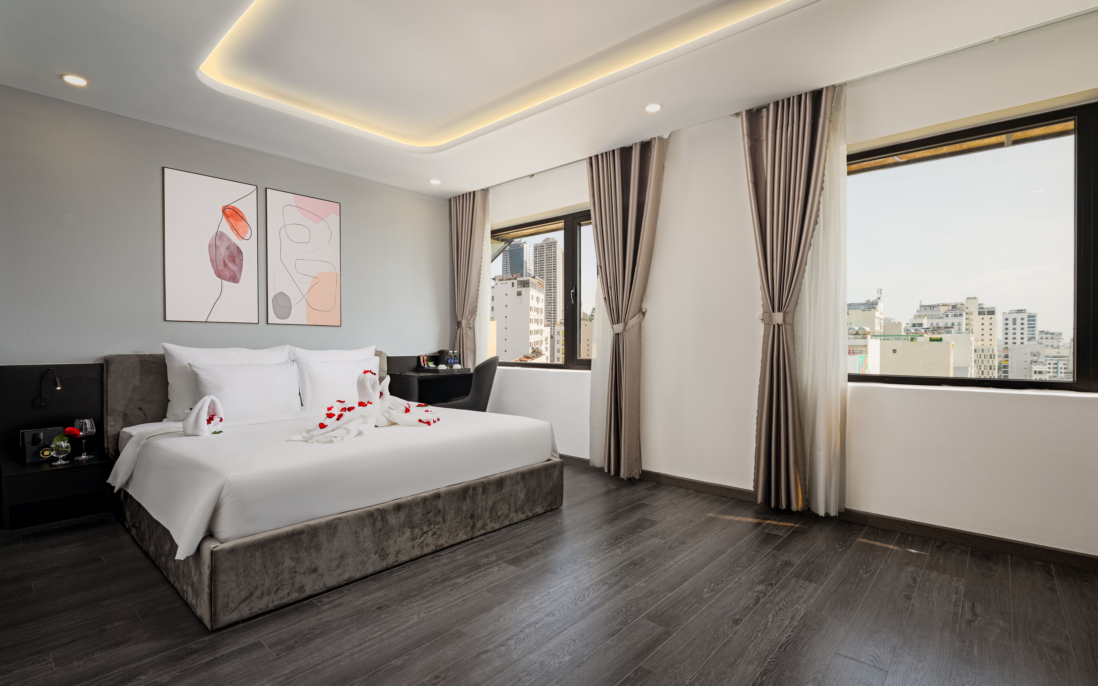 Une chambre d’hôtel moderne, dotée d’un grand lit, d’un bureau et offrant une vue sur la ville.