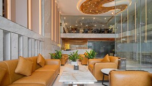 A modern hotel lobby with leather sofas, a marble coffee table, and potted plants. - MERCY EMERALD HOTEL (Da Nang)