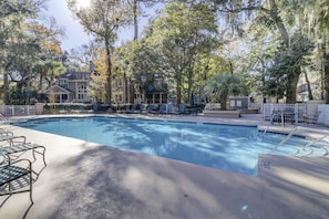 Relax by the serene pool surrounded by lush greenery and mature trees.