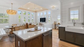 Una cocina amplia con una isla central, ventanas grandes y un diseño moderno.