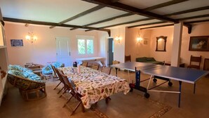 A dining area with a table set for six, a ping pong table, and a fireplace. - Hermosa Finca Rural (Navalmoral de bejar)