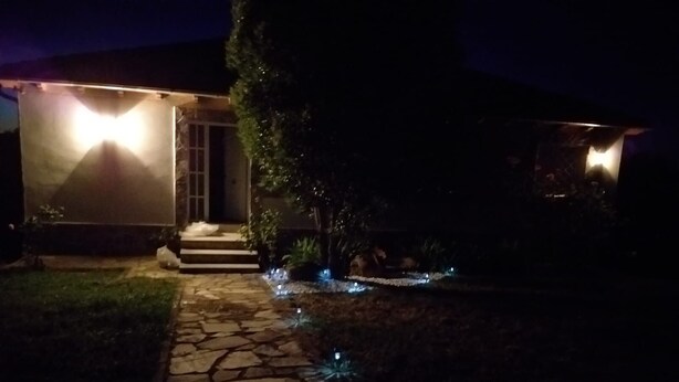 A house at night with a stone pathway leading to the entrance, illuminated by exterior lights. - Hermosa Finca Rural (Navalmoral de bejar)