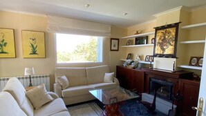 A living room with a sofa, a glass coffee table, and a fireplace. - Hermosa Finca Rural (Navalmoral de bejar)