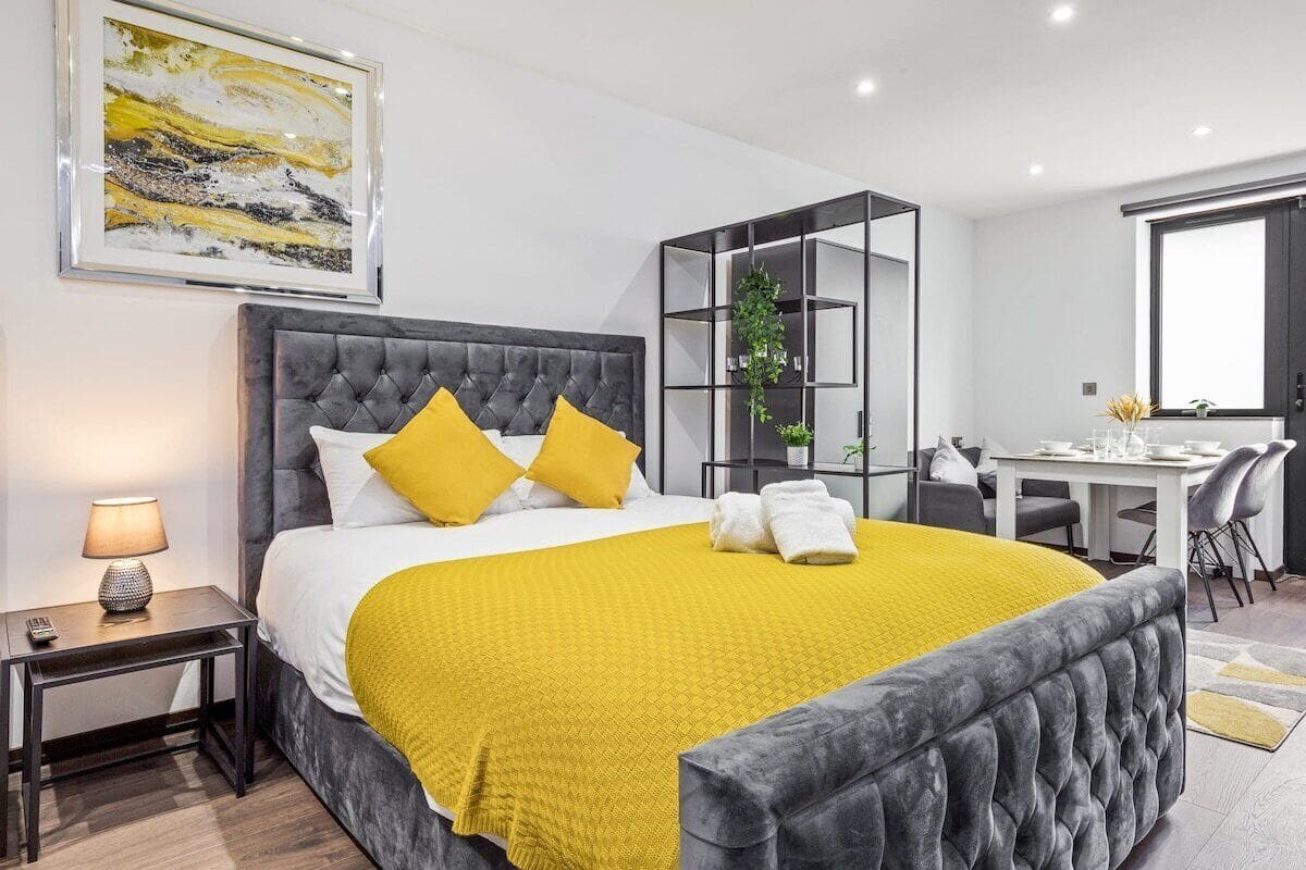 A modern hotel room with a large bed, a desk, and a chair.