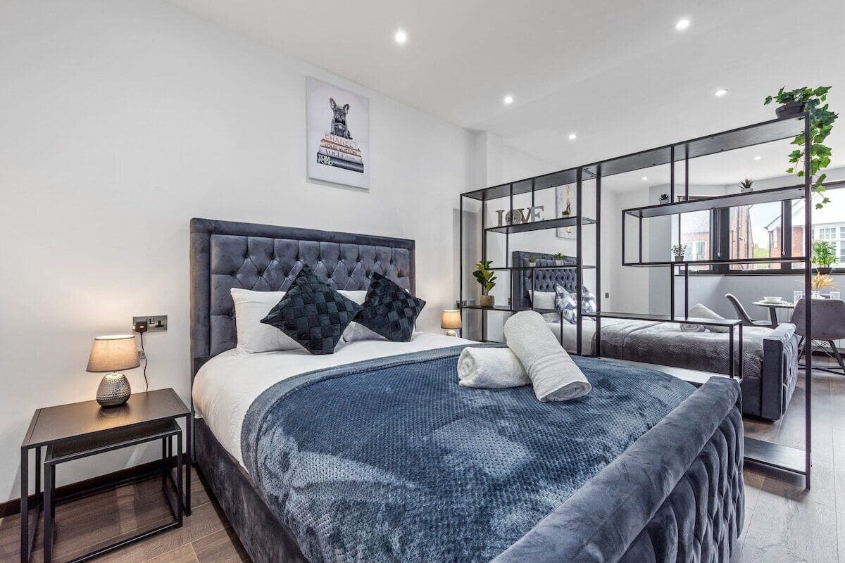 A modern bedroom with a large bed, a desk, and a chair.