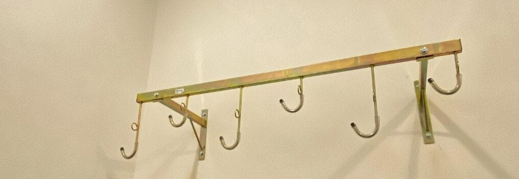 A metal coat rack with hooks against a plain wall.