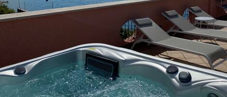 Un jacuzzi con vistas al mar y a las montañas.