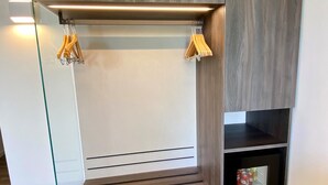 A modern room with a built-in bench, wooden panel walls, and a small shelving unit. - Hotel Pai (Torri del Benaco)