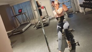 Et træningscenter med træningsudstyr, løbebånd og et spejl.