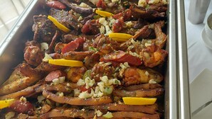 A buffet tray with roasted meats, vegetables, and garnishes. - Hotel Cacuaco (Cacuaco)