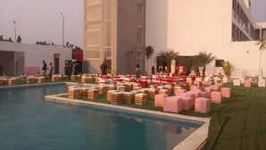 A pool area with lounge chairs and a building in the background. - Hotel Cacuaco (Cacuaco)