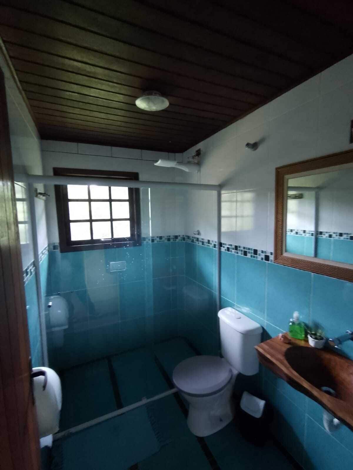 A small bathroom with a toilet, a sink, and a window.