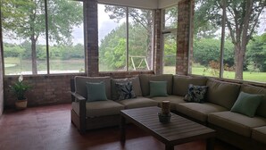 A cozy room with a large window, a sofa, and a coffee table. - Peaceful country getaway on a 2 acre pond (Folsom)
