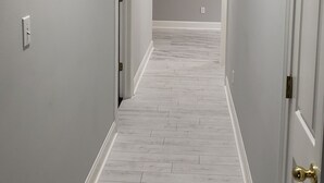 A hallway with white walls, a wooden floor, and a ceiling fan. - Peaceful country getaway on a 2 acre pond (Folsom)