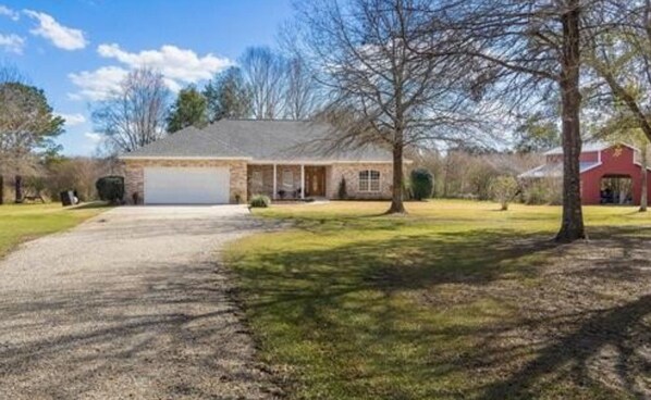A two-story house with a garage, a front porch, and a well-maintained lawn.