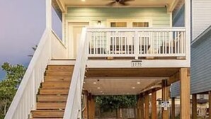 Une maison à deux étages dotée d’un porche avant couvert et d’un escalier menant à l’étage supérieur.