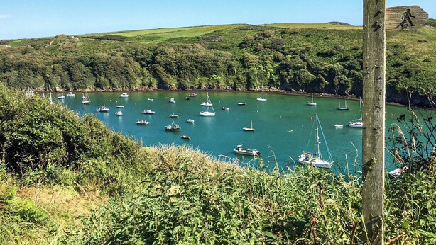 A coastal landscape with boats anchored in a bay, surrounded by lush greenery and hills. - 3 bedroom accommodation in Haverfordwest (Haverfordwest)