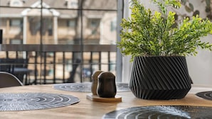A dining table with a potted plant, two salt and pepper shakers, and a decorative coaster. - Our Landing Place - Access to Pool! (Branson)