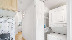 A compact kitchen with a white countertop, a hexagonal tile backsplash, and a white door leading to another room. - Our Landing Place - Access to Pool! (Branson)