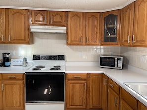 Enjoy cooking in this well-equipped kitchen with a stainless steel stove, microwave, and coffee maker.
