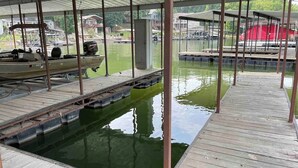 Ein überdachter Pool mit Holzterrasse und Steg.