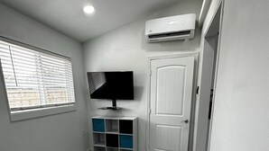 Una camera da letto con un letto, una televisione, un armadio e un condizionatore.
